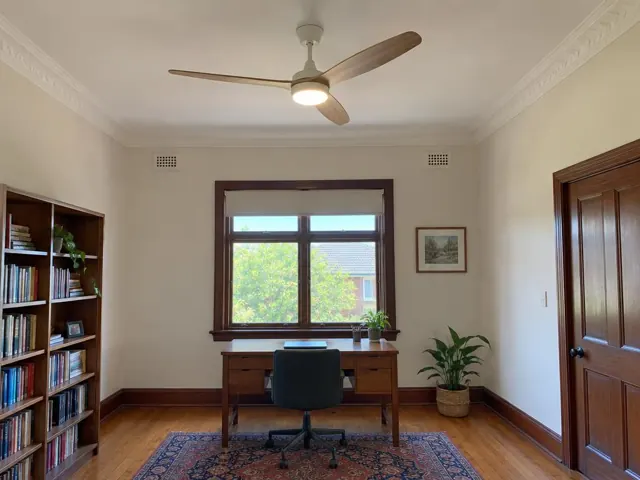 Ceiling fan in a timber-floored room with window, desk and bookshelves in Pennant Hills
